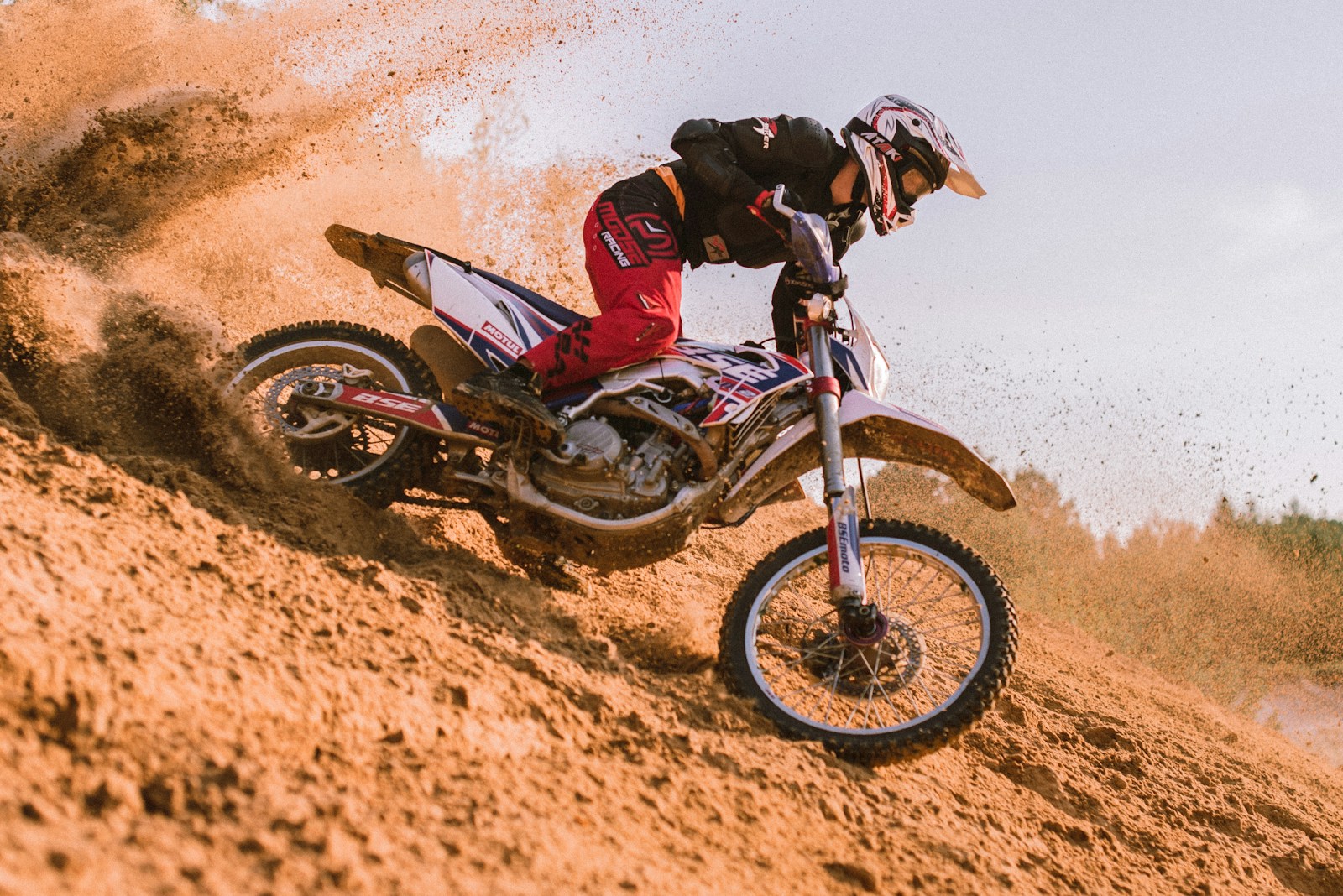 man in red and black motocross suit riding motocross dirt bike