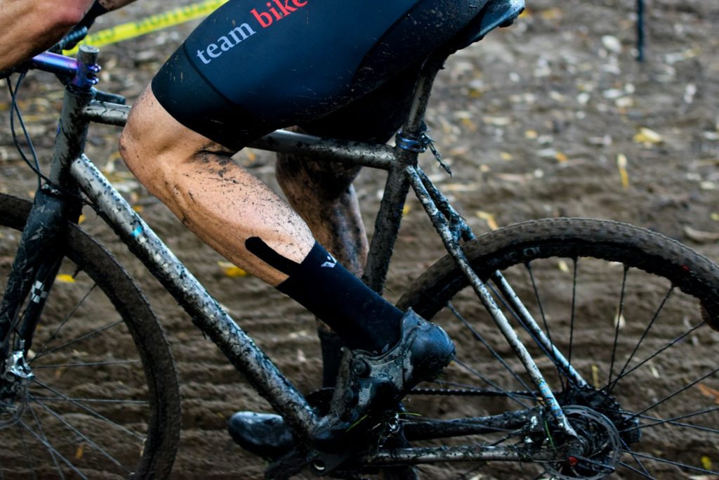 a man riding a bike down a muddy road